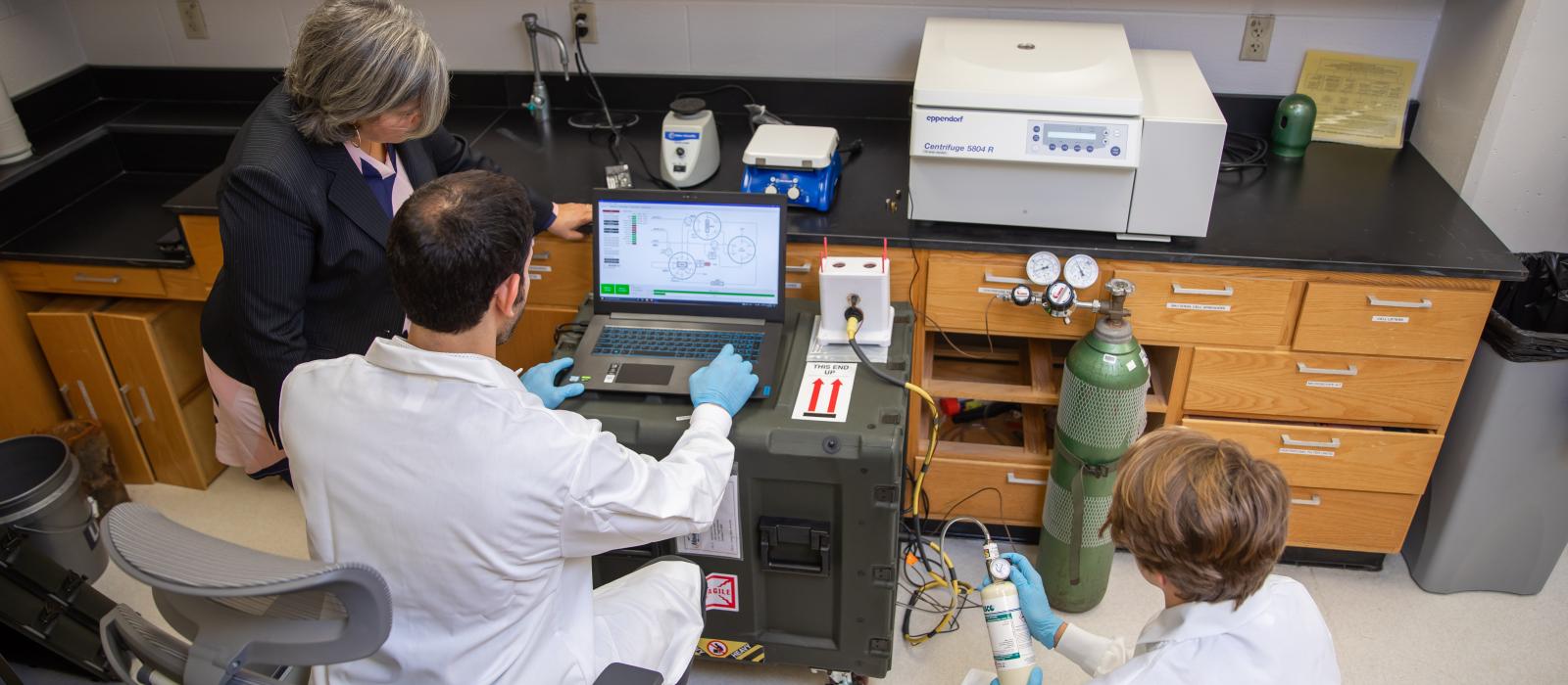 Researchers gathered around a computer screen in a lab