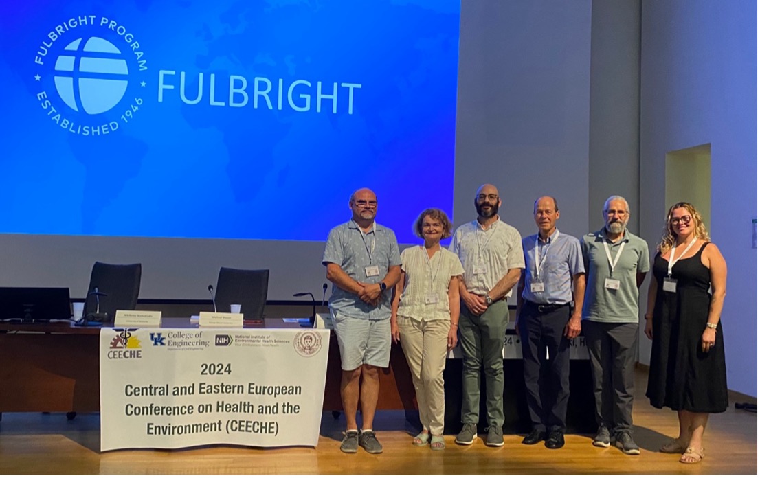 Researchers pose for a group photo on stage