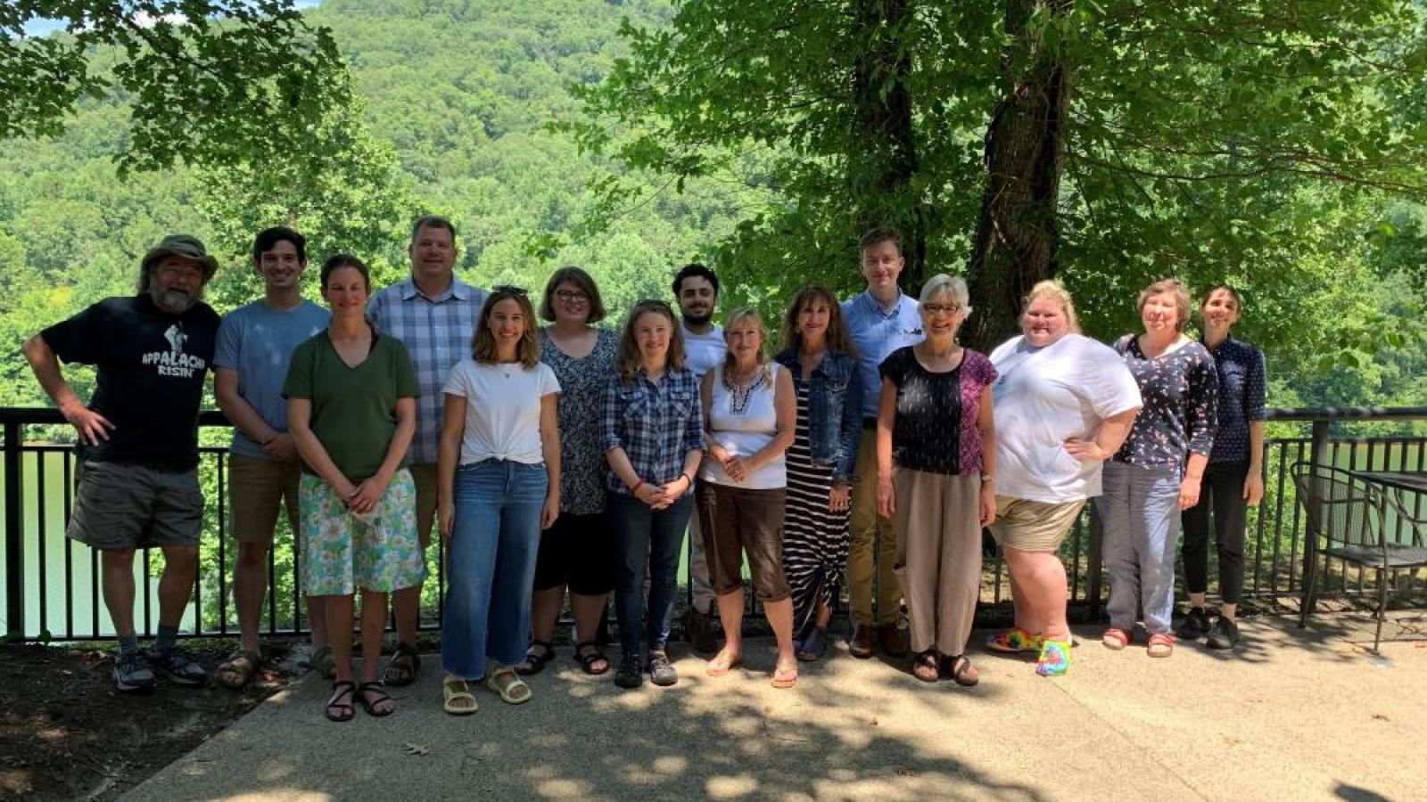 Group photo of researchers with wooded hills in the background