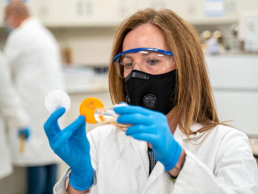 A researcher wearing glasses and a mask